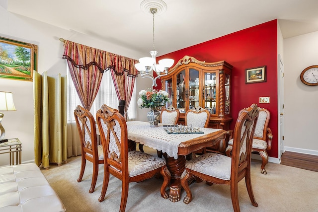 dining room featuring a chandelier and light carpet