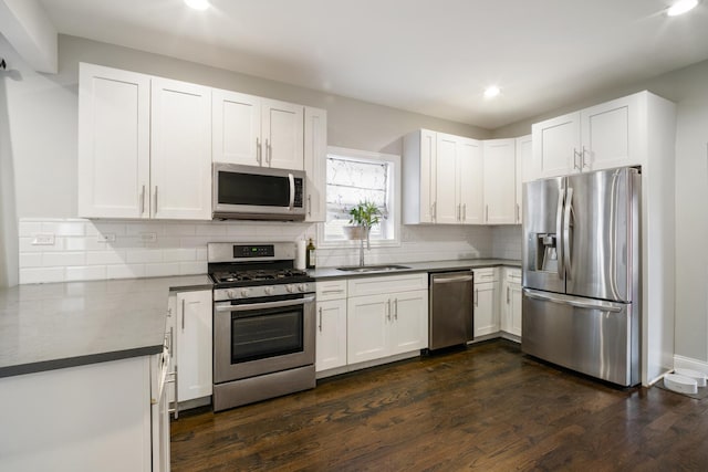 kitchen featuring white cabinetry, sink, dark wood-type flooring, and appliances with stainless steel finishes