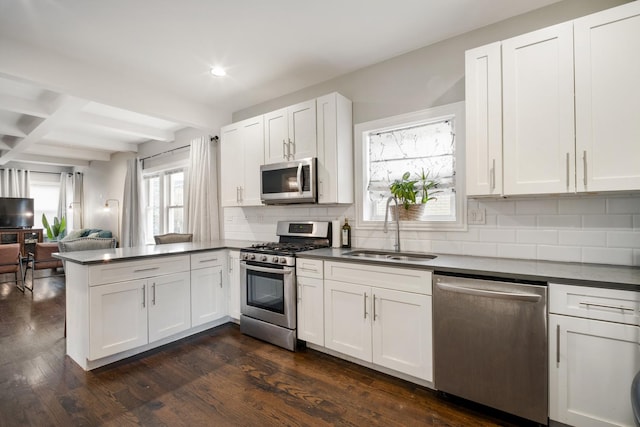 kitchen featuring white cabinetry, sink, dark wood-type flooring, decorative backsplash, and appliances with stainless steel finishes