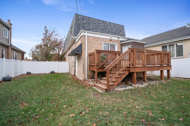 rear view of house featuring a yard and a deck