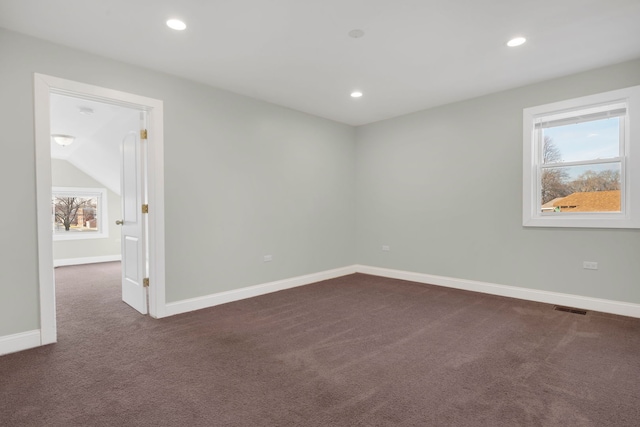 carpeted empty room featuring vaulted ceiling