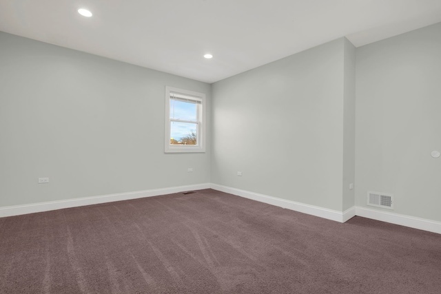 spare room featuring dark carpet