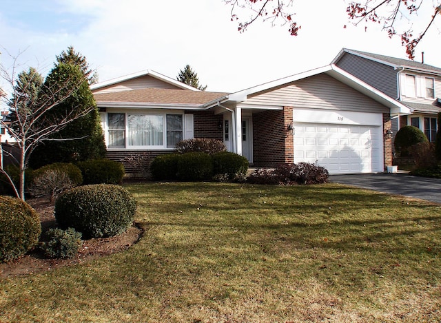 ranch-style house featuring a garage and a front lawn