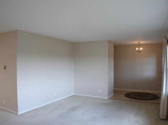 carpeted empty room featuring a notable chandelier