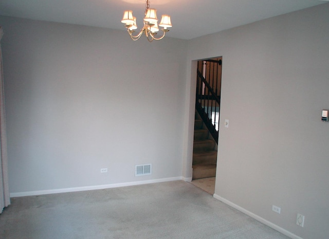 unfurnished room with light carpet and a chandelier