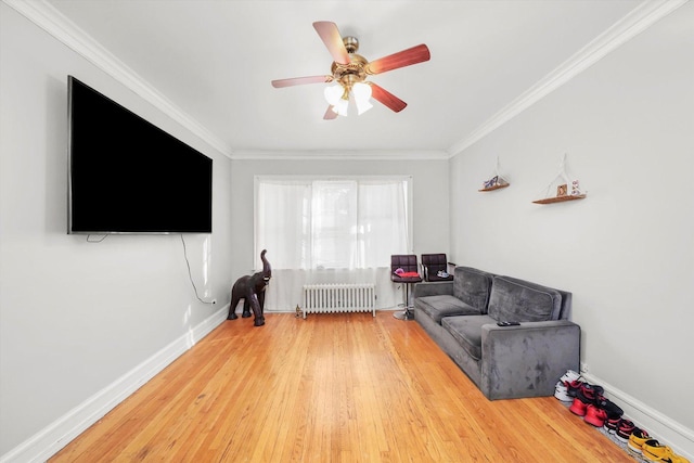 living room featuring radiator, crown molding, hardwood / wood-style floors, and ceiling fan