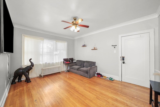 living area with crown molding, radiator heating unit, ceiling fan, and hardwood / wood-style flooring