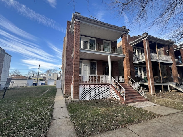 view of front of home with covered porch, a balcony, and a front lawn