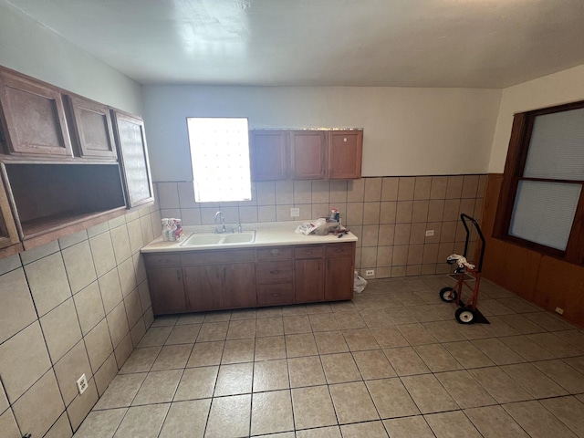 kitchen featuring sink, light tile patterned floors, and tile walls