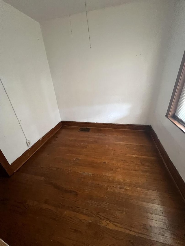 empty room with dark wood-type flooring