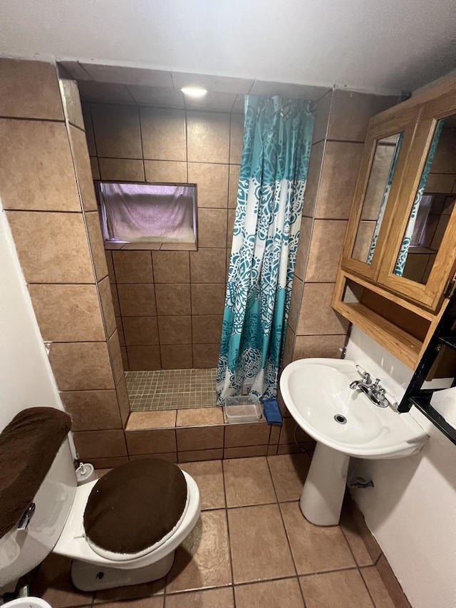 bathroom with a shower with shower curtain, tile patterned flooring, toilet, and sink