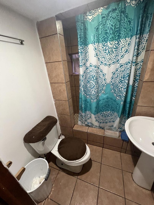 bathroom featuring tile patterned flooring, a shower with curtain, and toilet