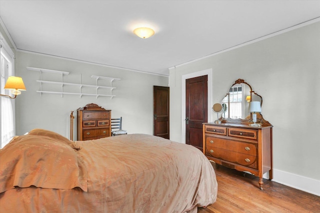 bedroom featuring hardwood / wood-style flooring and crown molding