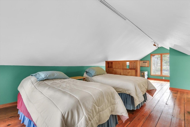 bedroom featuring lofted ceiling, hardwood / wood-style floors, and track lighting