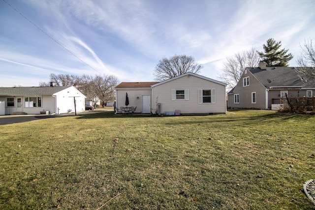 back of house with a lawn