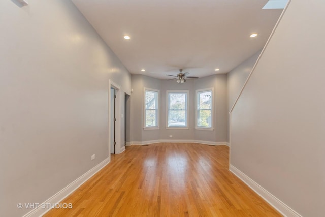 empty room featuring light wood-type flooring and ceiling fan