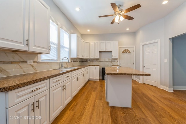 kitchen with white cabinets, a center island, and sink