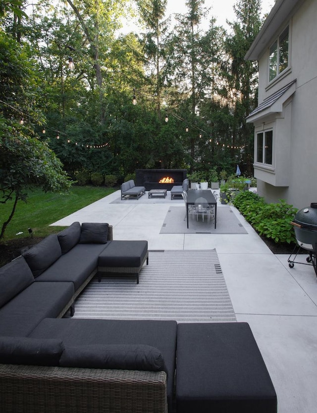 view of patio with an outdoor living space with a fire pit