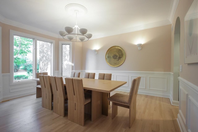 dining area with plenty of natural light, an inviting chandelier, ornamental molding, and light hardwood / wood-style flooring