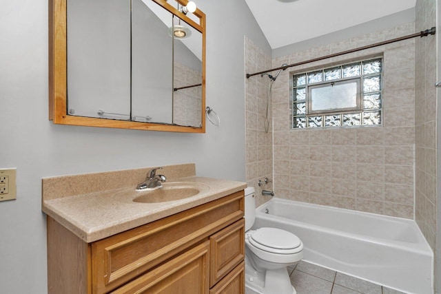 full bathroom featuring tile patterned floors, vaulted ceiling, toilet, vanity, and tiled shower / bath