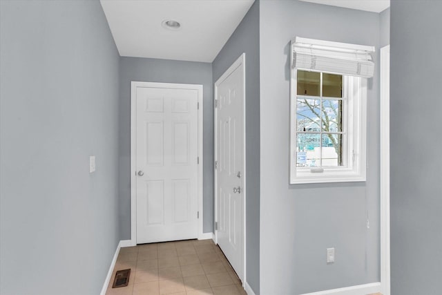 hall featuring light tile patterned floors