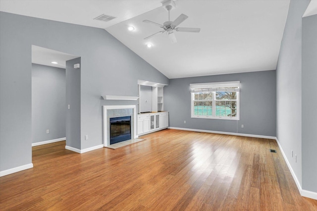 unfurnished living room with ceiling fan, light hardwood / wood-style flooring, a fireplace, and vaulted ceiling