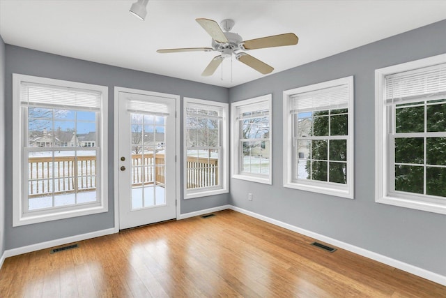 unfurnished sunroom with ceiling fan and a healthy amount of sunlight