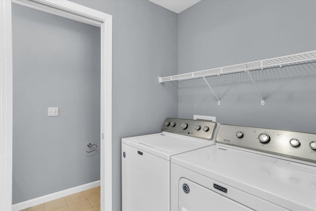 clothes washing area with separate washer and dryer and light tile patterned floors