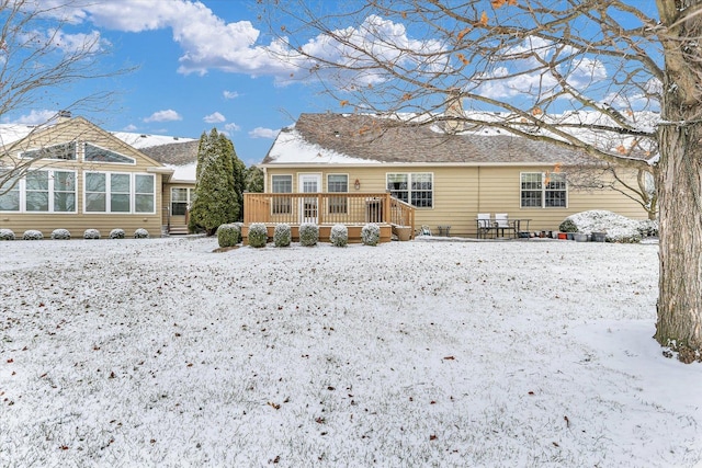 snow covered rear of property featuring a deck