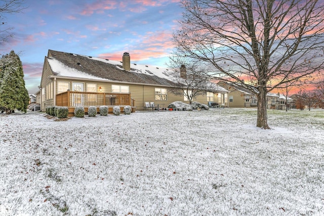 snow covered house with a wooden deck