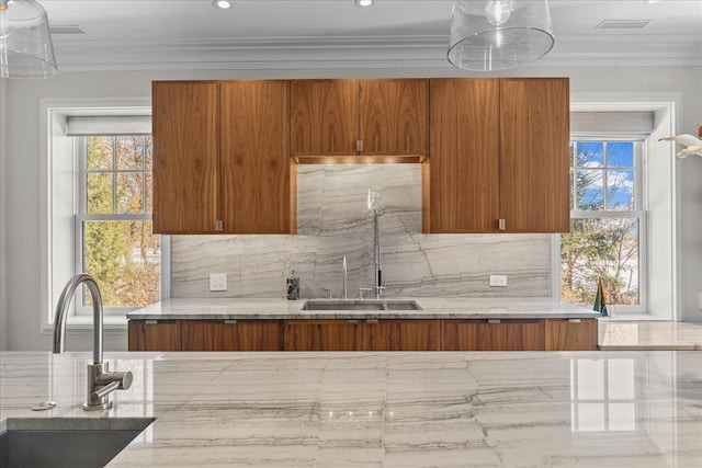 kitchen with crown molding, light stone countertops, sink, and decorative backsplash