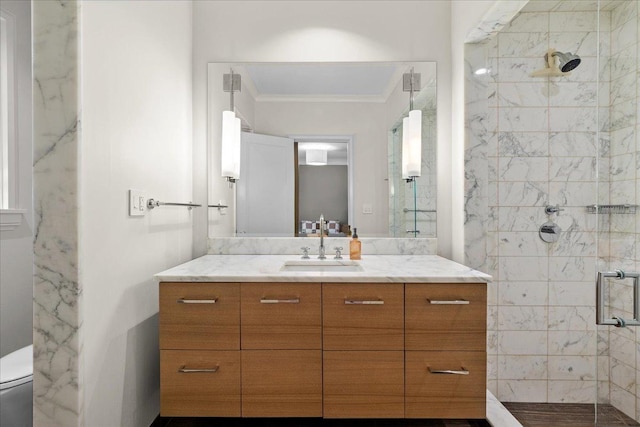 bathroom with vanity, ornamental molding, an enclosed shower, and toilet