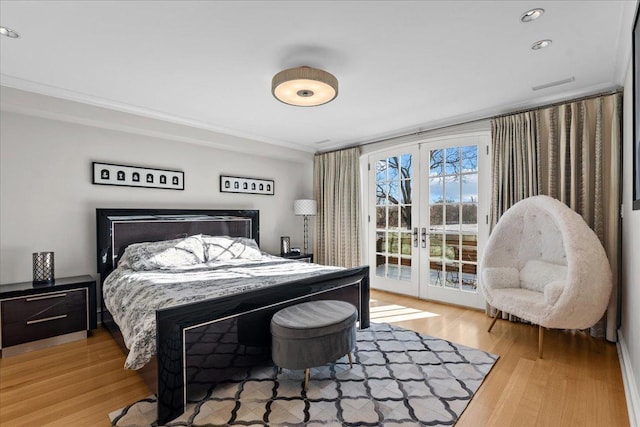 bedroom featuring crown molding, access to outside, light wood-type flooring, and french doors