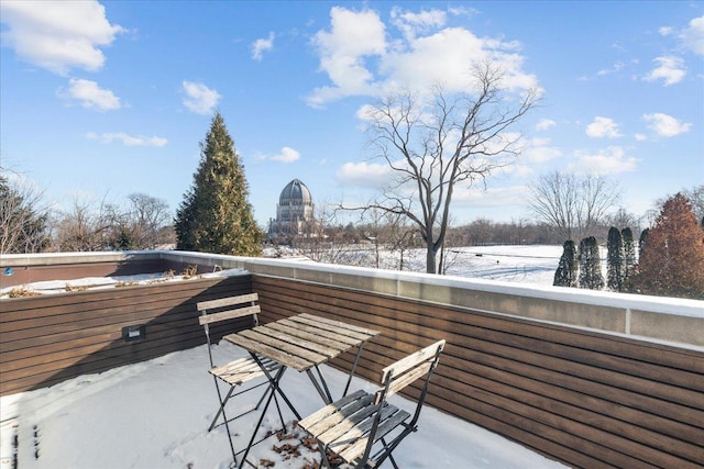 view of snow covered back of property