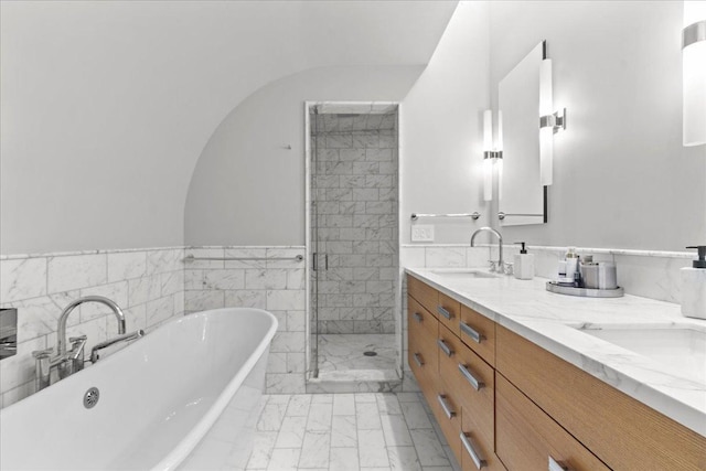 bathroom featuring vanity, shower with separate bathtub, and tile walls