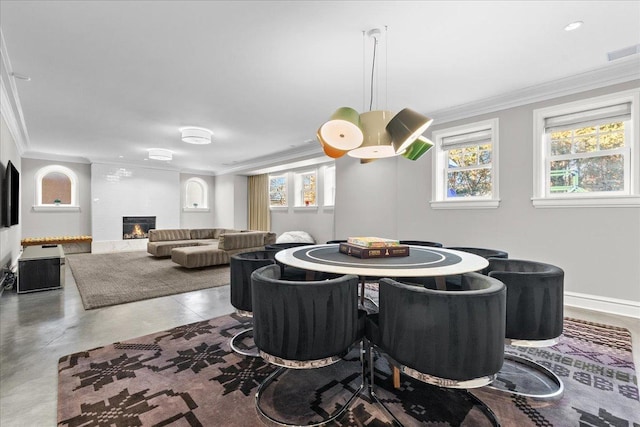 dining room featuring ornamental molding, plenty of natural light, and a fireplace