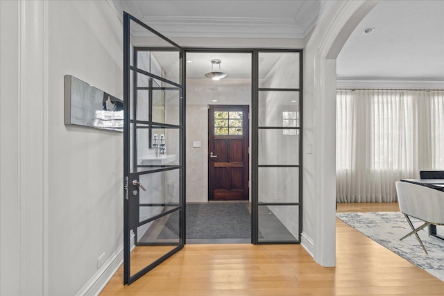 foyer with crown molding and light wood-type flooring