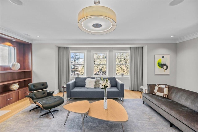 living room with crown molding, a healthy amount of sunlight, and light wood-type flooring