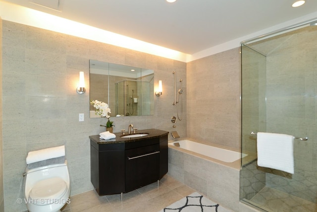 full bathroom with tile patterned flooring, separate shower and tub, toilet, and tile walls