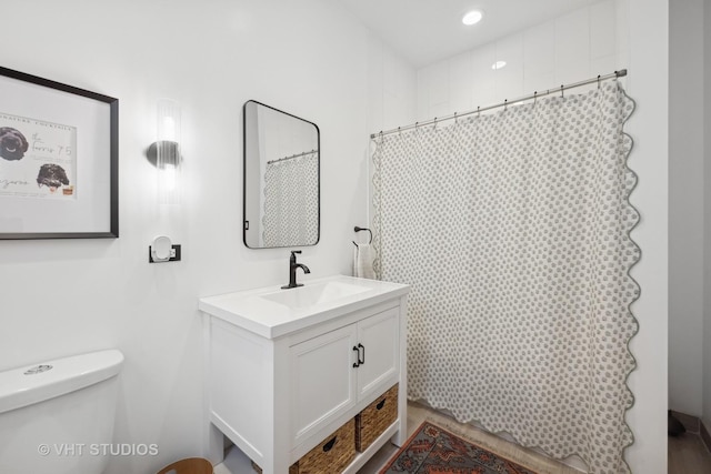 bathroom featuring vanity, toilet, and walk in shower