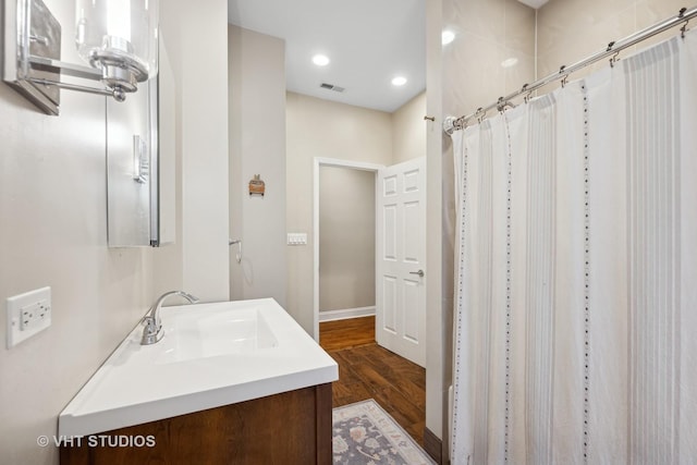 bathroom with a shower with shower curtain, hardwood / wood-style floors, and vanity