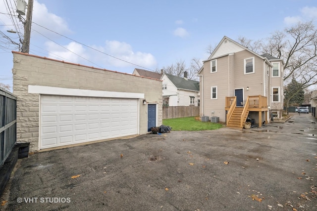 back of property with a garage and central AC unit