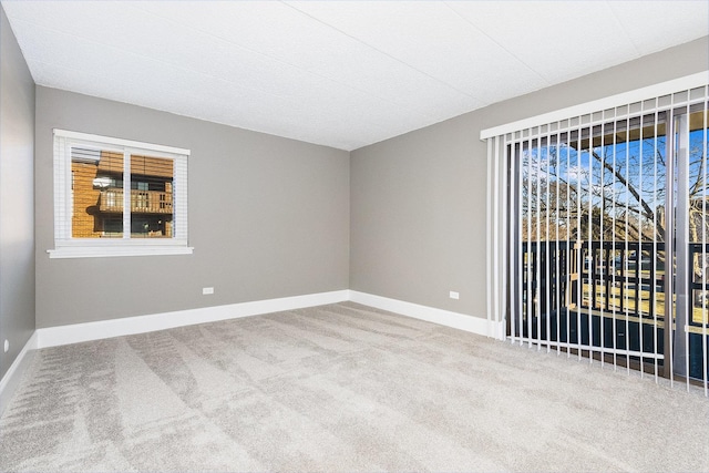 carpeted empty room with baseboards