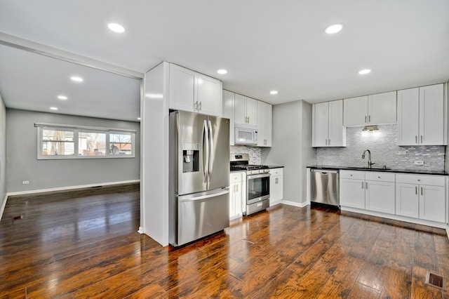 kitchen with white cabinetry, sink, dark wood-type flooring, and appliances with stainless steel finishes