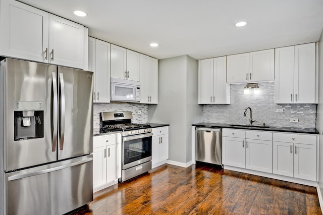 kitchen featuring appliances with stainless steel finishes, dark hardwood / wood-style flooring, tasteful backsplash, sink, and white cabinets