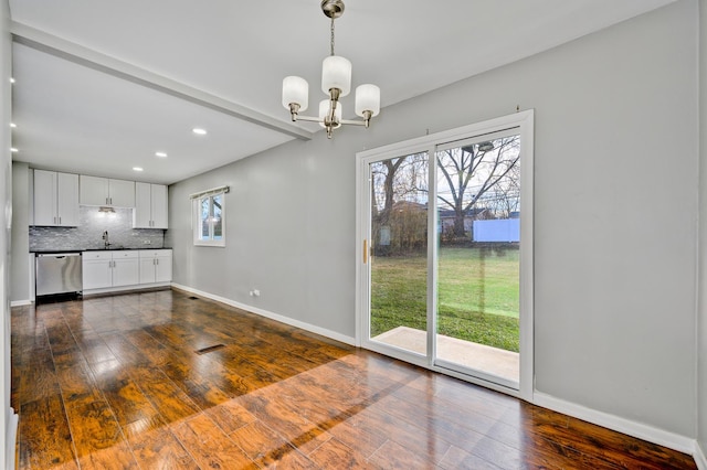 interior space with dishwasher, white cabinets, dark hardwood / wood-style floors, and a chandelier