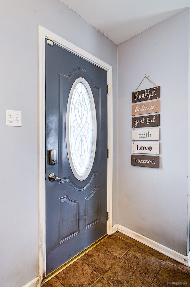 entryway with dark tile patterned floors