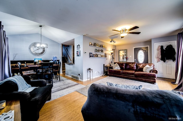 living room featuring light hardwood / wood-style flooring, ceiling fan with notable chandelier, and lofted ceiling