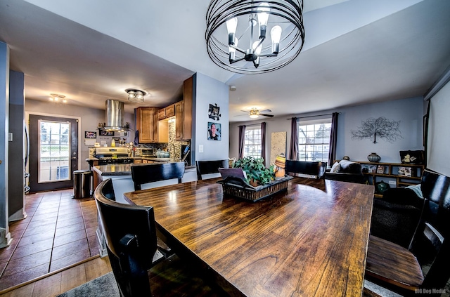 dining room featuring tile patterned flooring, ceiling fan with notable chandelier, and a healthy amount of sunlight