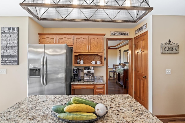 kitchen featuring light stone counters, stainless steel fridge with ice dispenser, and dark hardwood / wood-style floors